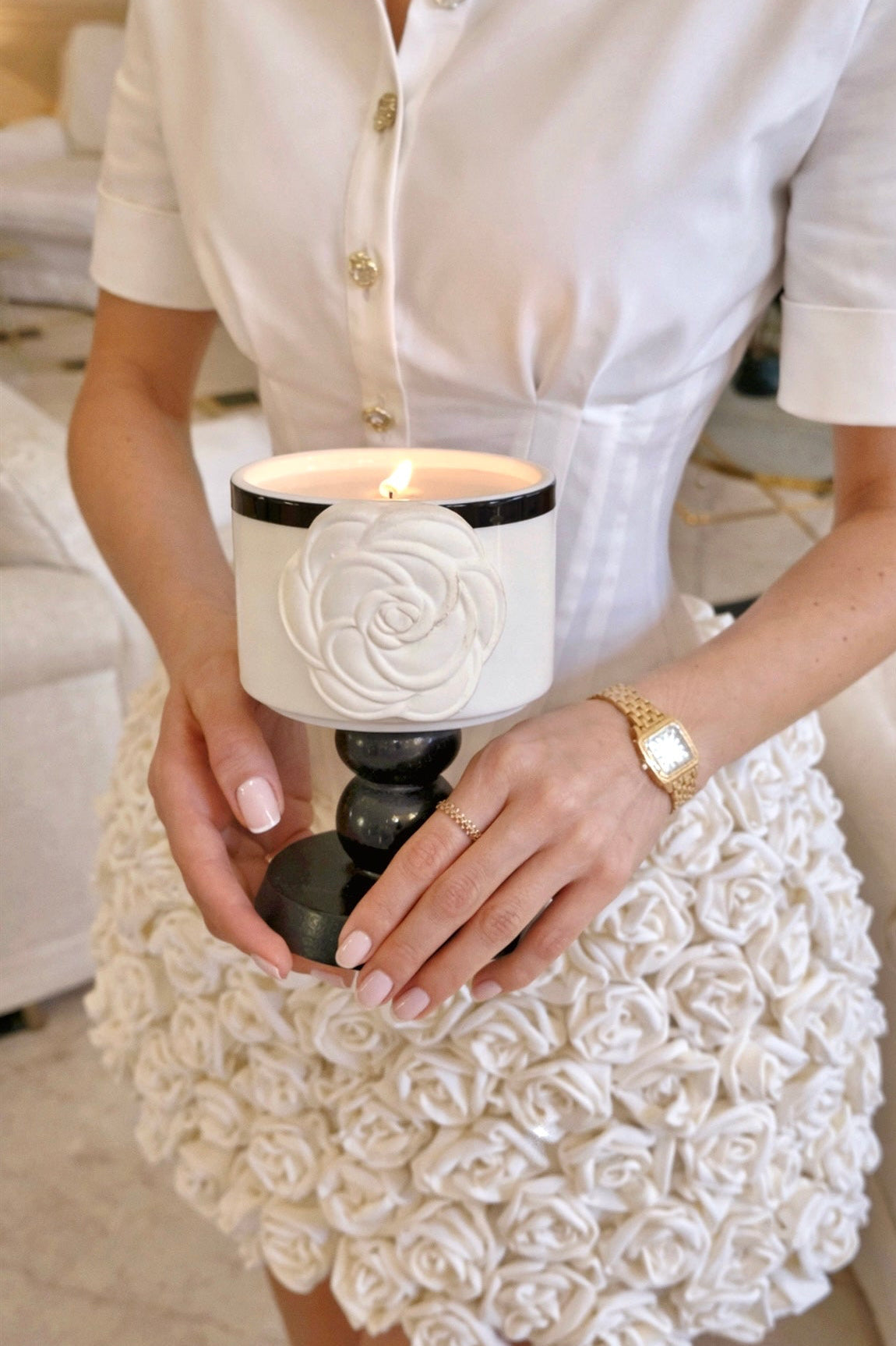 An elegant woman holding the Camélia Maison Candle, designed by Anaïs Candle