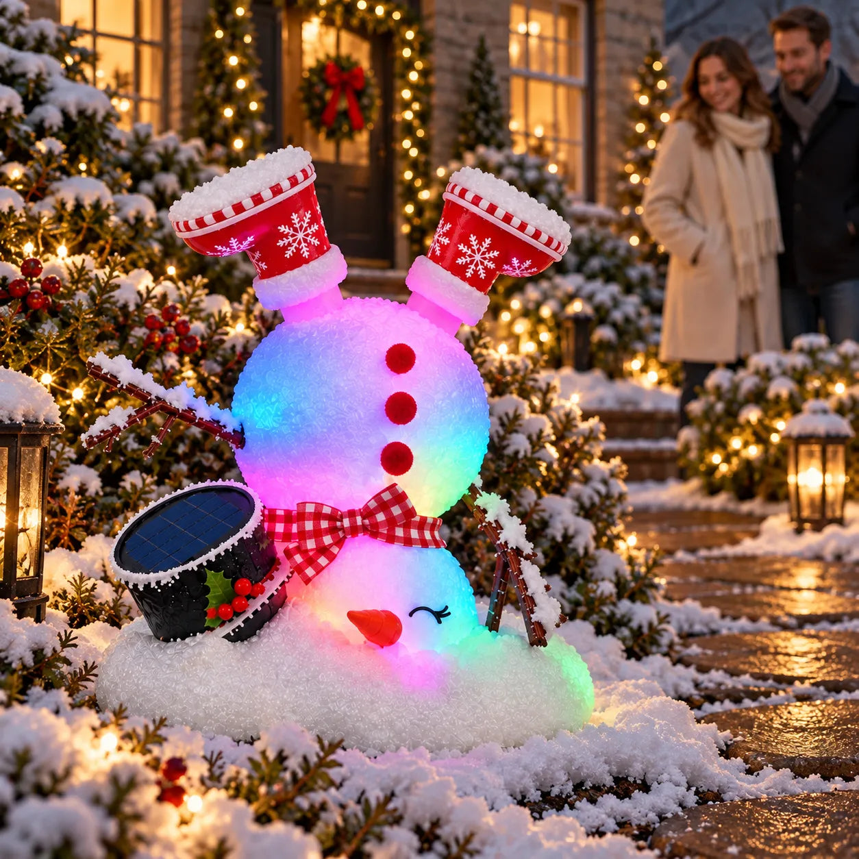Color-changing solar snowman with upside-down red boots, snowflake details and a glowing body in a Christmas garden at night