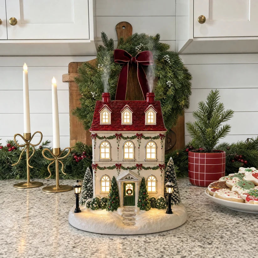 Christmas cottage aroma diffuser with glowing windows and gentle chimney mist in a festive kitchen