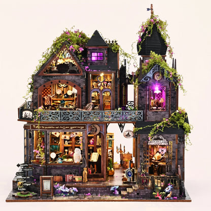 The Witch's Lair DIY miniature gothic mansion kit glowing amber and violet on a blush background