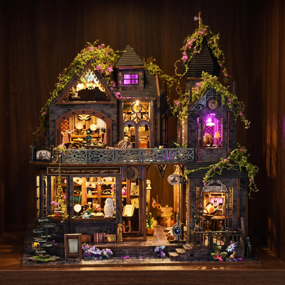 The Witch's Lair glowing at night on a dark walnut shelf, violet attic light